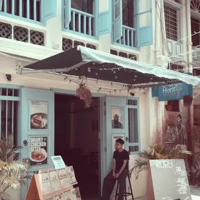 A blue-shuttered café in Kuala Lumpur, shot on Kachak, at full strength on day one.